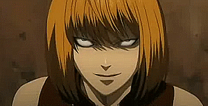 Mello bites off a piece of chocolate while he stares at the screen menacingly