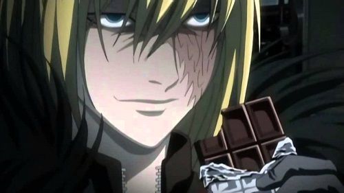 Mello holding an unwrapped chocolate bar that already has a bite in it