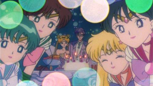 Minako Aino eyes shut and smiling, Rei Hino smiling and looking at Chibiusa, Mamoru Chiba standing behind birthday cake, Bishoujo Senshi Sailor Moon R